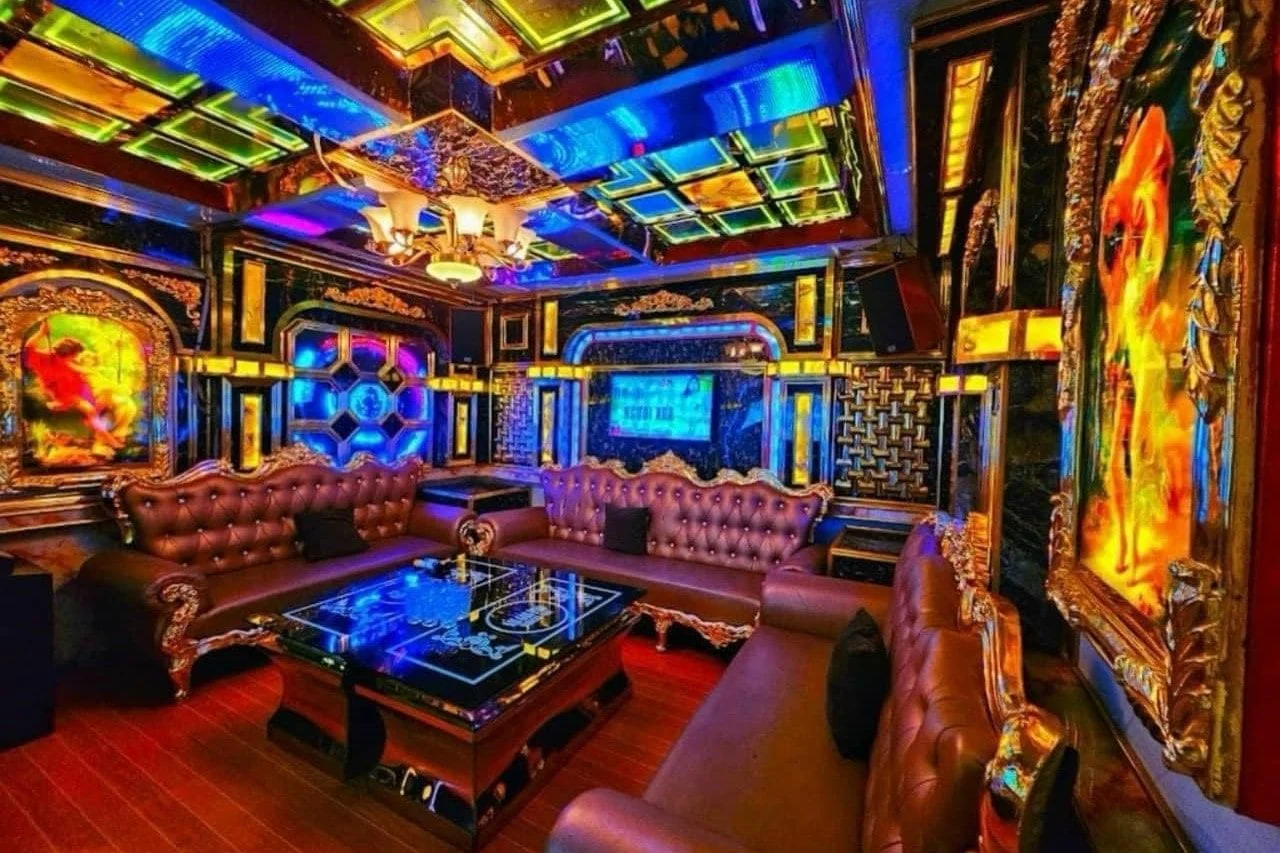 Phòng VIP trần vàng xanh, sofa da nâu, bàn kính LED
