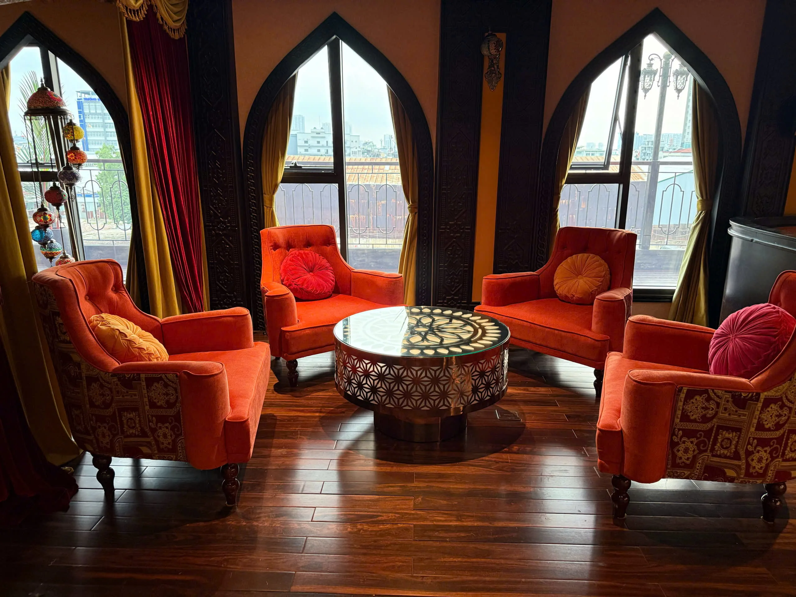 Góc ghế ngồi màu cam cạnh cửa sổ vòm trong REVER Lounge