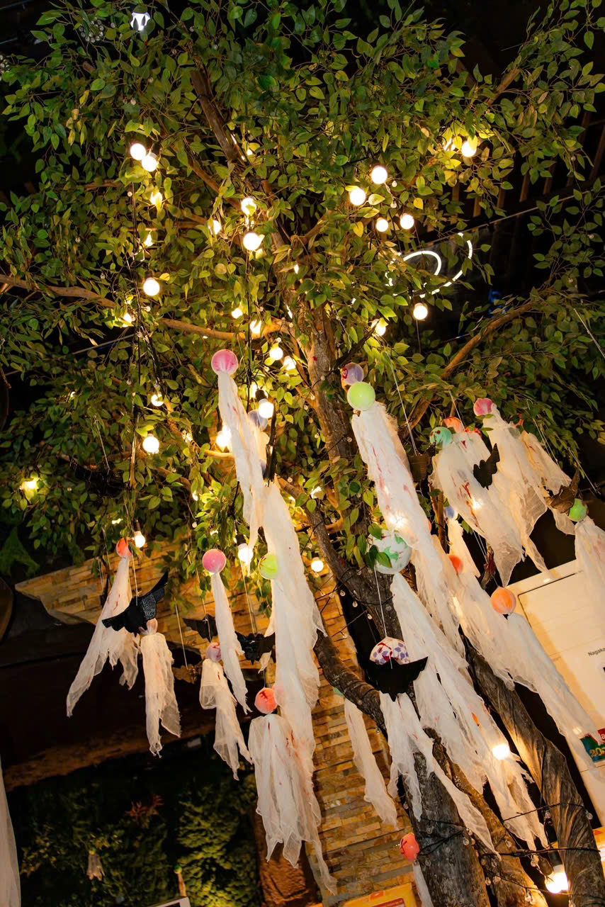 Cây trang trí đèn vàng và vải trắng tại Bảo Garden