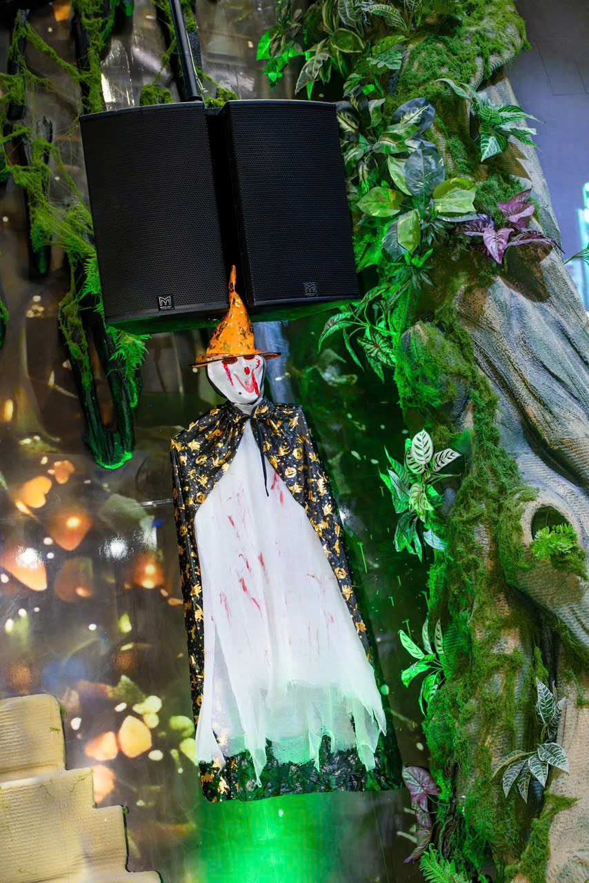 Hình nộm phù thủy Halloween giữa mảng cây xanh tại Bảo Garden