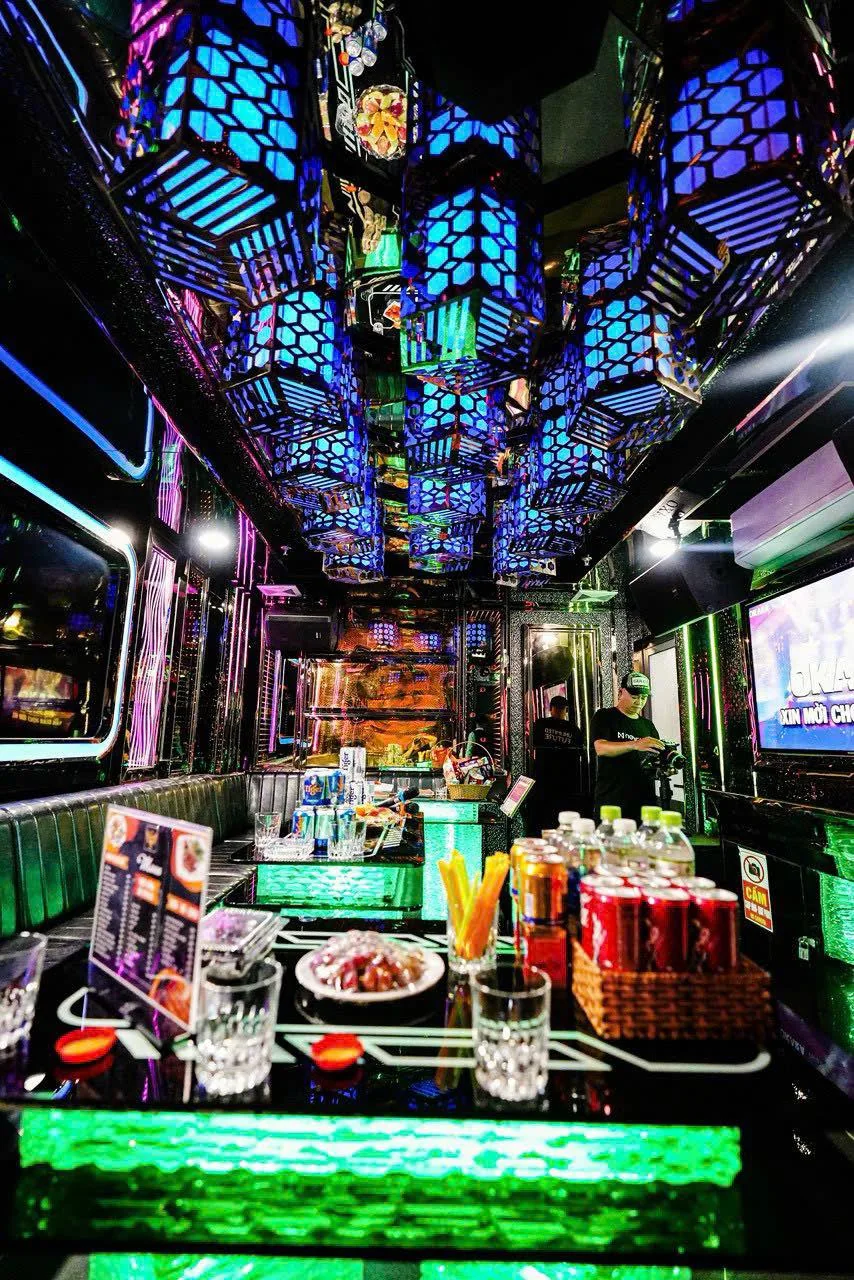 Các khối đèn trần xanh phản chiếu trong gương của phòng karaoke